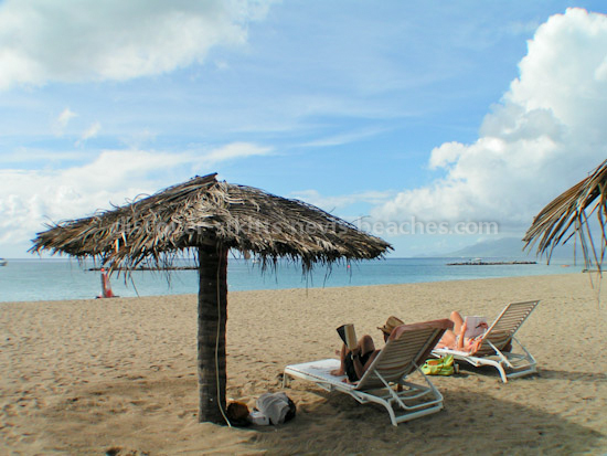 Photo of tourists relaxing on Pinnneys Beach in Nevis. Perfect spot for a family beach vacation.